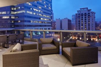 Outdoor terrace overlooking Director Park, with a fireplace feature and grilling station